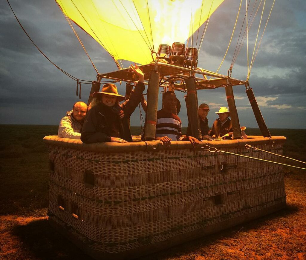 Group of travelers getting started early before the sun rises over the Serengeti, Tanzania