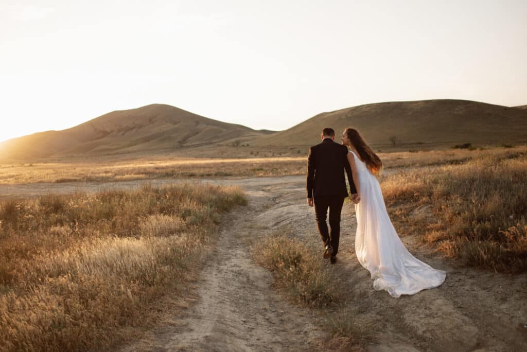 Bride and groom walking in the African Bush at Sunset