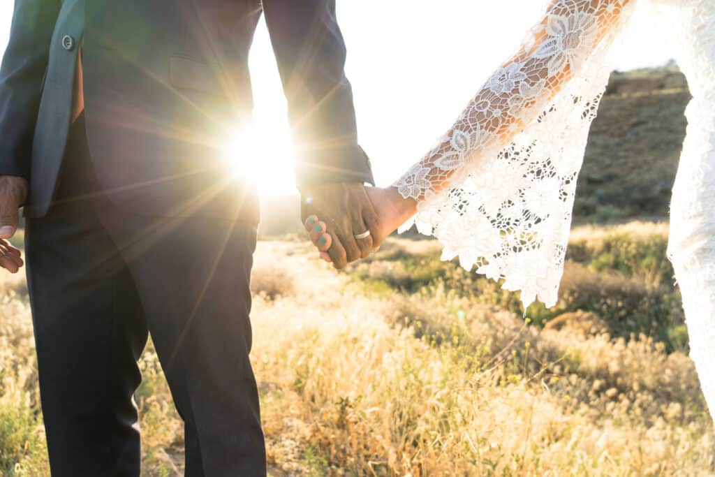 Couple holding hands on wedding day in African Bush