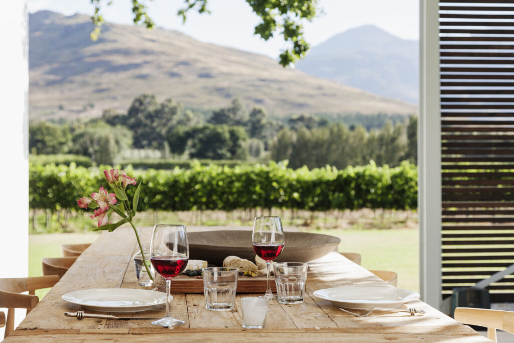 Dining table and chairs on a patio overlooking a vineyard in South Africa. Photo: Getty Images