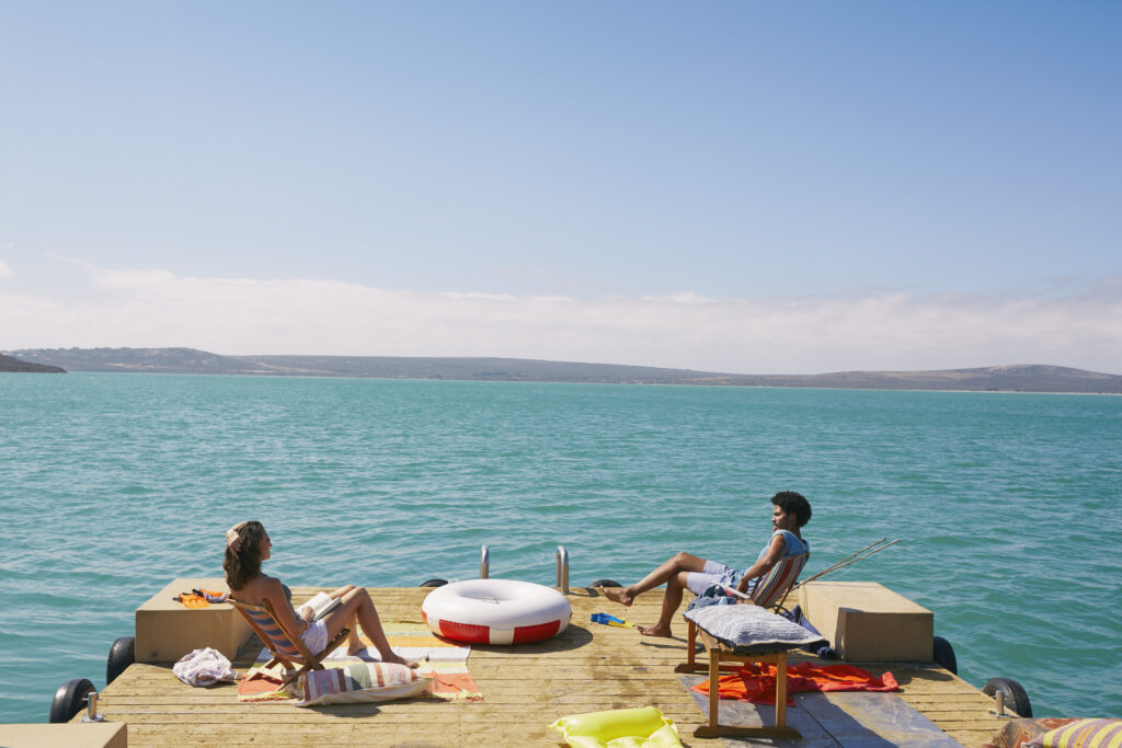 Couple relaxing on houseboat sun deck, Kraalbaai, South Africa