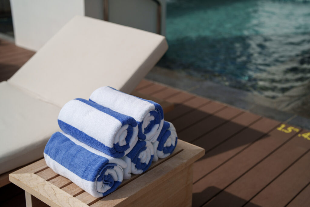 Rolled towels on a wooden table poolside. Photo: Getty Images