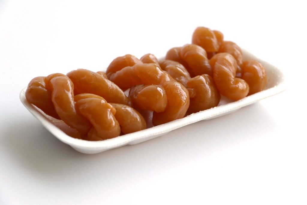 Sweet koeksisters covered in syrup, placed in a polystyrene tray. Photo: Getty Images