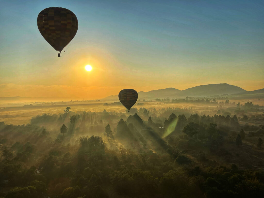 View of hot air balloons flying over the Magaliesberg valley at sunrise. Photo: Getty Images