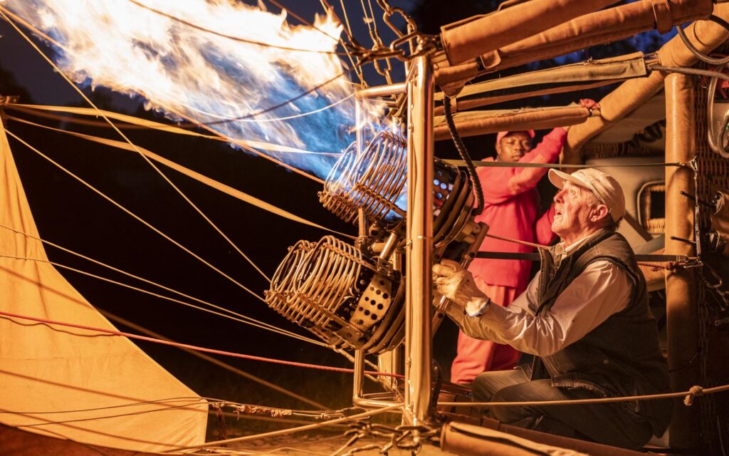 Crew members in the basket preparing a hot-air balloon for take off