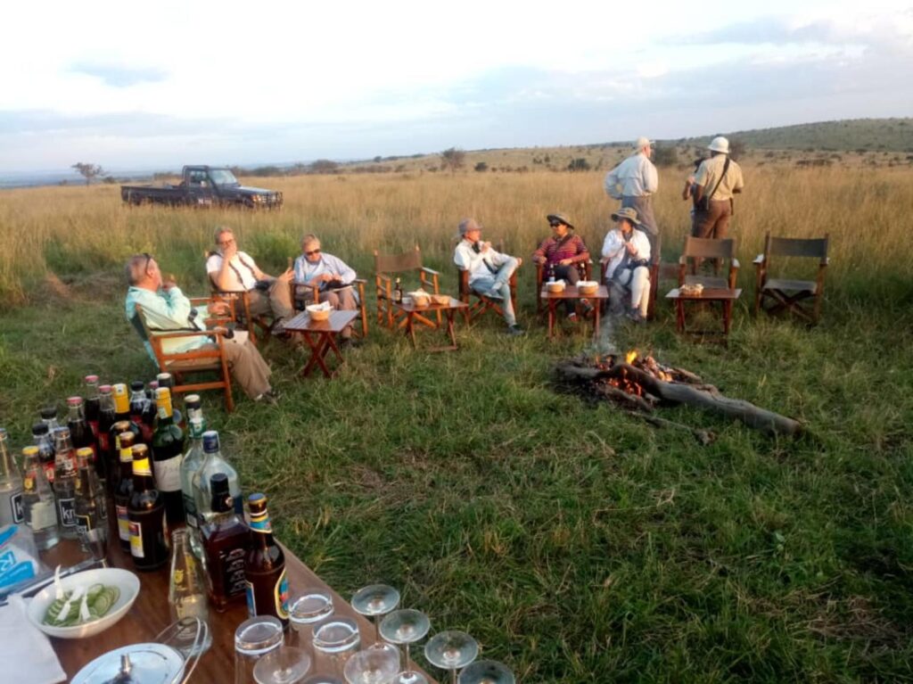 Group of people sitting in a circle at camp | Photo credit: Nasikia Mobile